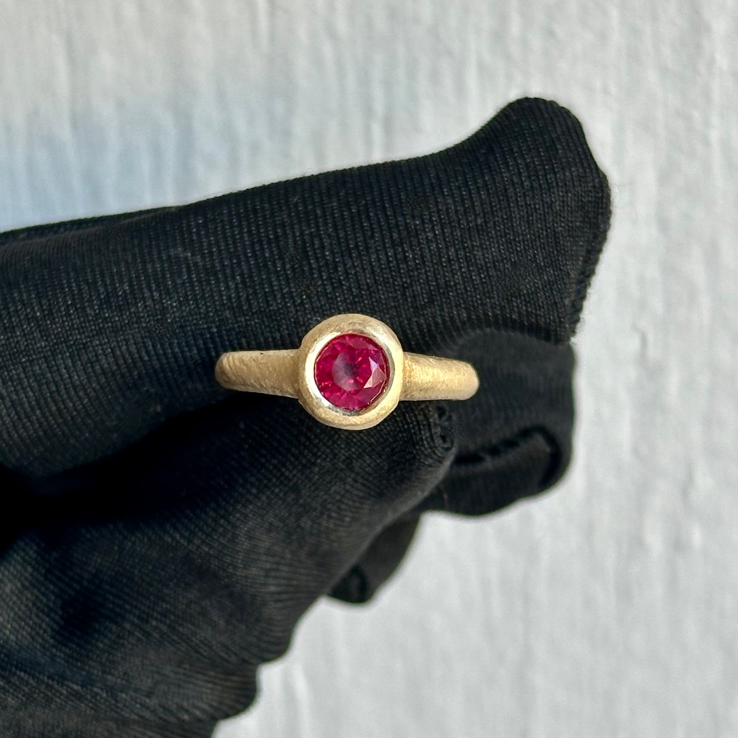 Round Cut Ruby 0.60ct Vivid Red in Color – Handmade 18kt Yellow Gold Bezel Setting with Sandblast Hammered Finish – Designed & Crafted In-House at Facets Fine Jewelry